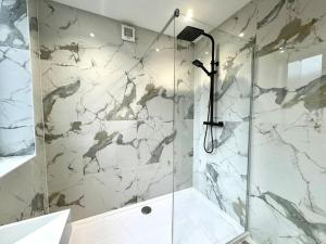 baño con ducha y puerta de cristal en Coastal 3BR Bournemouth Apartment, Prime Location, en Bournemouth