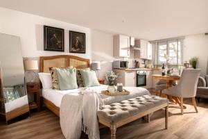 une chambre avec un grand lit et une cuisine dans l'établissement Meadow - Woodland Cottage with Private Hot Tub, à Blandford Forum