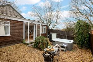 a bath tub in the backyard of a house at Meadow - Woodland Cottage with Private Hot Tub in Blandford Forum