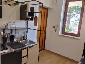 La cuisine est équipée d'un évier et d'un réfrigérateur. dans l'établissement Garden House Alla Torre, à Isola delle Femmine