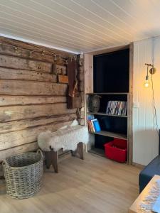 Habitación con pared de madera, banco y estantería. en Lofoten- Feriehus Fjøsen, en Ørsvåg 28 fotos más