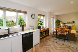 a kitchen and dining room with a table and a clock at Amazing City Centre Home in Derby