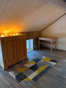 an attic room with a table and a rug at Lofoten- Feriehus Fjøsen in Ørsvåg