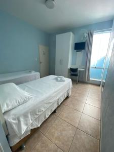 - une chambre avec un lit et une chaise dans l'établissement POUSADA OASIS DE MINAS, à Carmo do Rio Claro