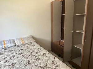 a small bedroom with a bed and a closet at Casa do Sossego in Guaibim