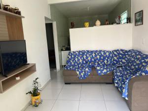 a living room with a couch and a television at Casa do Sossego in Guaibim