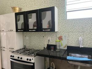 瓜賓的住宿－Casa do Sossego，厨房配有炉灶和白色冰箱。
