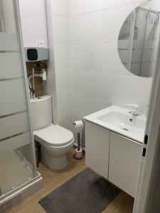 Un baño blanco con inodoro y lavabo. en Appartement lumineux près métro, en Saint-Denis