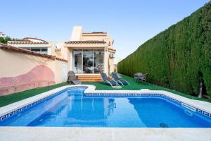 a villa with a swimming pool in front of a house at Can Lucia in Miami Platja
