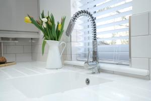 a kitchen sink with a faucet and a vase of flowers at Lucas in Sudbury