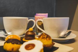 two coffee cups and muffins on a table at Emerald Green Residence in Caldiero