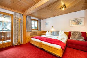 1 dormitorio con 1 cama y alfombra roja en Laubichlhof, en Flachau