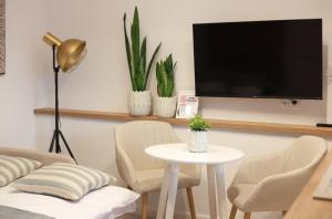 sala de estar con mesa, sillas y TV en 2 Apartament Miętowy Rumianek, en Lwówek