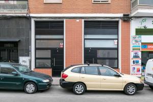 two cars parked in front of a brick building at Beautiful duplex in front of Vista Alegre Palace in Madrid