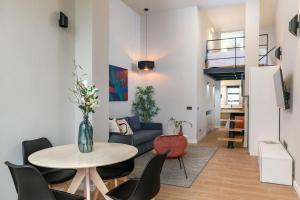 a living room with a table and chairs at Beautiful duplex in front of Vista Alegre Palace in Madrid