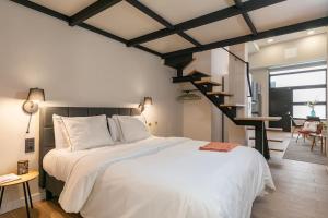 a bedroom with a large bed and a staircase at Beautiful duplex in front of Vista Alegre Palace in Madrid