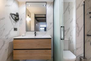 a bathroom with a sink and a toilet and a mirror at Beautiful duplex in front of Vista Alegre Palace in Madrid +19 photos
