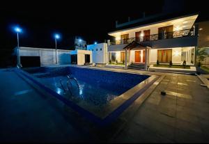 una piscina di fronte a una casa di notte di GRB RESORT a Tiruchchendūr