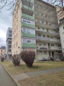 un grand immeuble d'appartements avec un bush devant lui dans l'établissement 3-Zimmer-Wohnung-Kalvariengürtel, à Graz