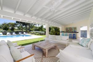a living room with white furniture and a pool at Coral House 3 bedroom home in Saint Peter