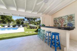 a kitchen with a bar with stools and a swimming pool at Coral House 3 bedroom home in Saint Peter