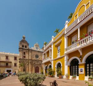 a group of buildings with a church in the background at Bahari Cartagena Suites in Cartagena de Indias