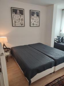- une chambre avec un lit noir et deux photos sur le mur dans l'établissement 3-Zimmer-Wohnung-Kalvariengürtel, à Graz