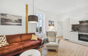 LoxstedtにあるFerienwohnung Majaのリビングルーム(革張りのソファ、椅子付)