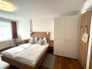 a bedroom with a white bed and a white cabinet at Ferienwohnungen Sommer in Bad Radkersburg
