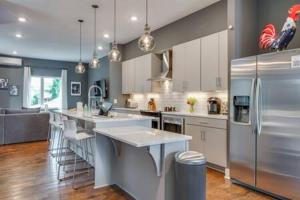 a large kitchen with stainless steel appliances and a kitchen island at Twin Homes of Art & Rooftops, Free Night Promo! in Nashville