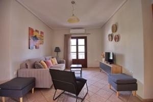 a living room with a couch and a tv at Pefka Apartments in Votsi
