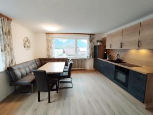 a kitchen with a table and a couch and a table at Carina's Apartment in Obsteig
