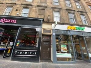 a store fronts on a street in front of a building at Pass the Keys Artistic and Stylish 2 Bedroom Flat in City Centre in Glasgow