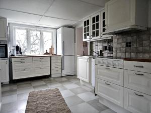 a kitchen with white cabinets and a large window at Idylliskt Hus Nära Lysekil & Skaftö in Uddevalla