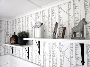 a room with a white shelf with a tree wallpaper at Idylliskt Hus Nära Lysekil & Skaftö in Uddevalla