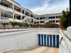 um edifício com uma garagem azul e branca em Apartament z widokiem na morze Playa de Los Naufragos em Torrevieja