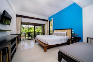 1 dormitorio con 2 camas, TV y balcón en Railay Princess Resort & Spa, en Railay Beach