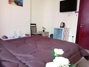 Bett mit lila Daunendecke in einem Zimmer in der Unterkunft Fabulous Luxury Room in Abu Dhabi