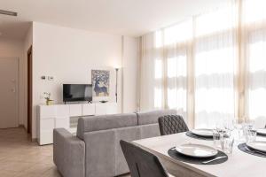 a living room with a couch and a table with chairs at Angelico Modern Living in Florence