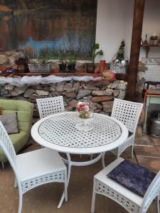 uma mesa branca e cadeiras com uma taça de fruta em Green room em Knysna