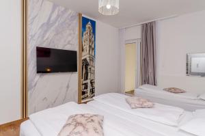 a bedroom with two white beds and a flat screen tv at Apartments Villa Niko in Trogir +59 photos