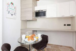 LE PROVENCAL - Center old Antibes 1BR flat with AC, wifi في أنتيب: مطبخ مع طاولة عليها صحن من الطعام