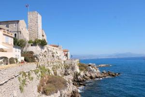 a view of the ocean and buildings on a cliff at LE PROVENCAL - Center old Antibes 1BR flat with AC, wifi in Antibes