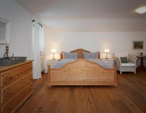 - une chambre avec un grand lit en bois et un lavabo dans l'établissement Haus Katrin, à Bad Hindelang
