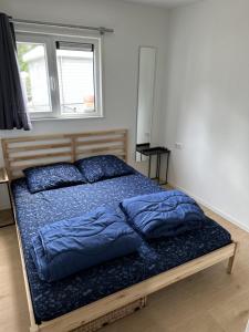 a bed with blue pillows on it in a bedroom at Bospark Wolfsven - BPW 1110 in Mierlo