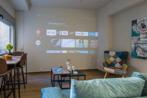 a living room with a large screen on the wall at Elegant, Spacious and hitech apt at Koukaki in Athens