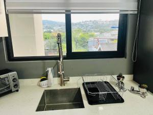 a kitchen counter with a sink and a window at Elegante y acogedor apartamento en el corazón de San Salvador in San Salvador