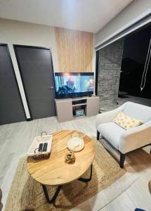a living room with a coffee table and a tv at Elegante y acogedor apartamento en el corazón de San Salvador in San Salvador