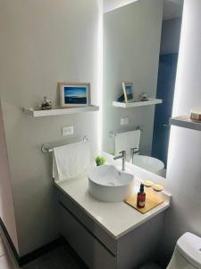 a white bathroom with a sink and a toilet at Elegante y acogedor apartamento en el corazón de San Salvador in San Salvador