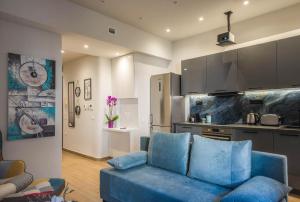 a living room with a blue couch and a kitchen at Elegant, Spacious and hitech apt at Koukaki in Athens